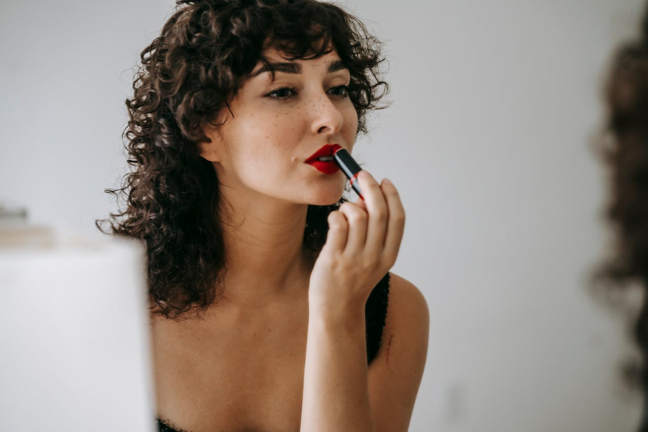 red lips with glowy skin and curly hair style